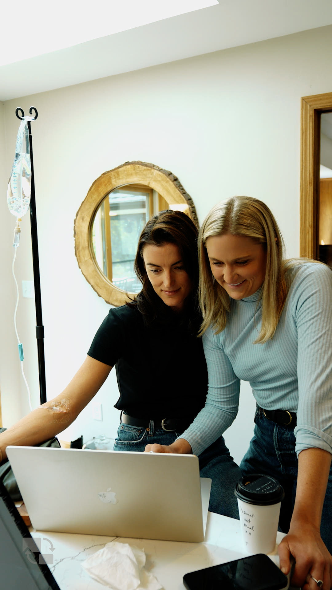 Two of the team leaning in over a laptop, sharing a quiet moment